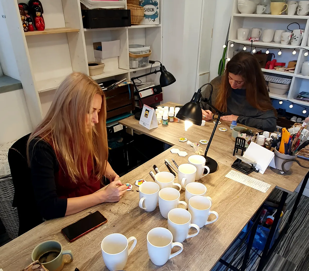Alexandra y Cristina pintando tazas en el taller de Lullula en Sibiu
